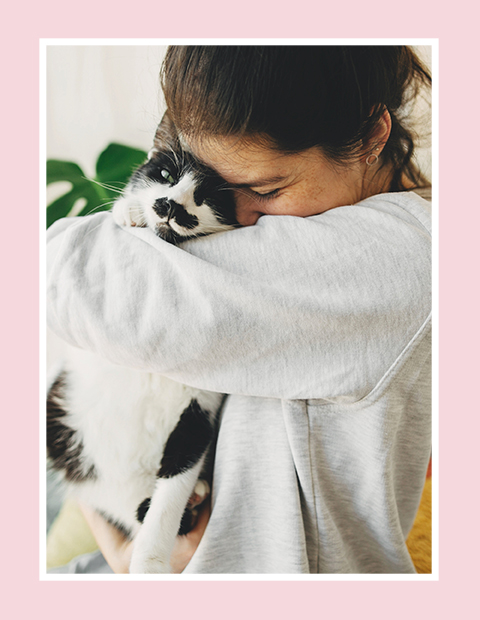 Young lady hugging a black and white cat