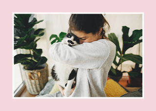 Young lady hugging a black and white cat